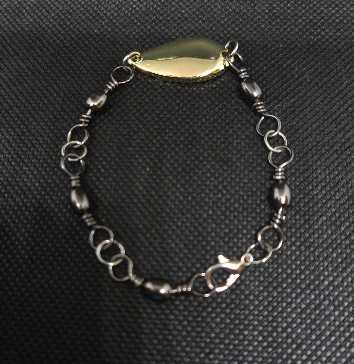 Fishing swivel bracelet with gold spoon lure