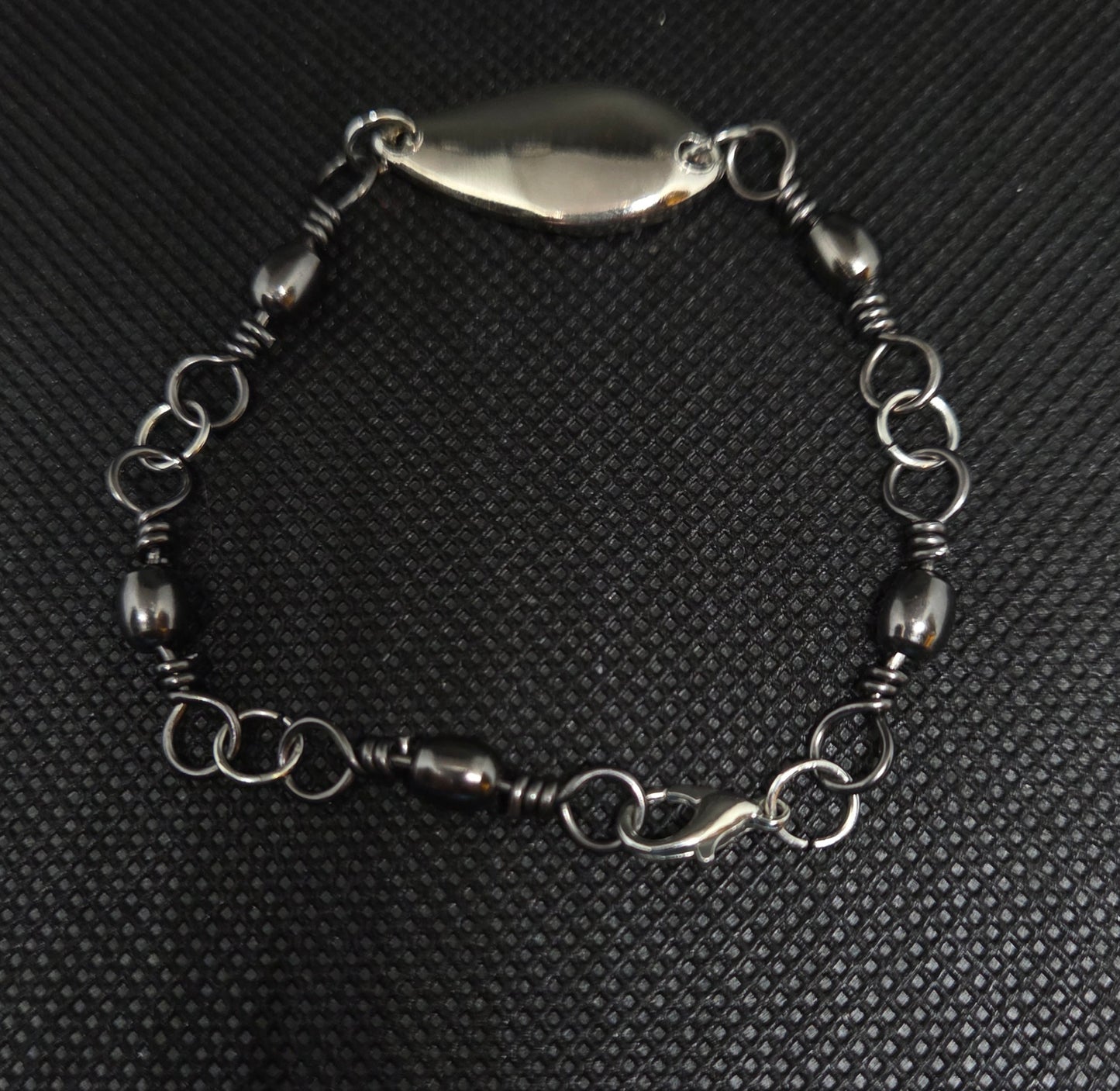 Fishing swivel bracelet with silver spoon lure