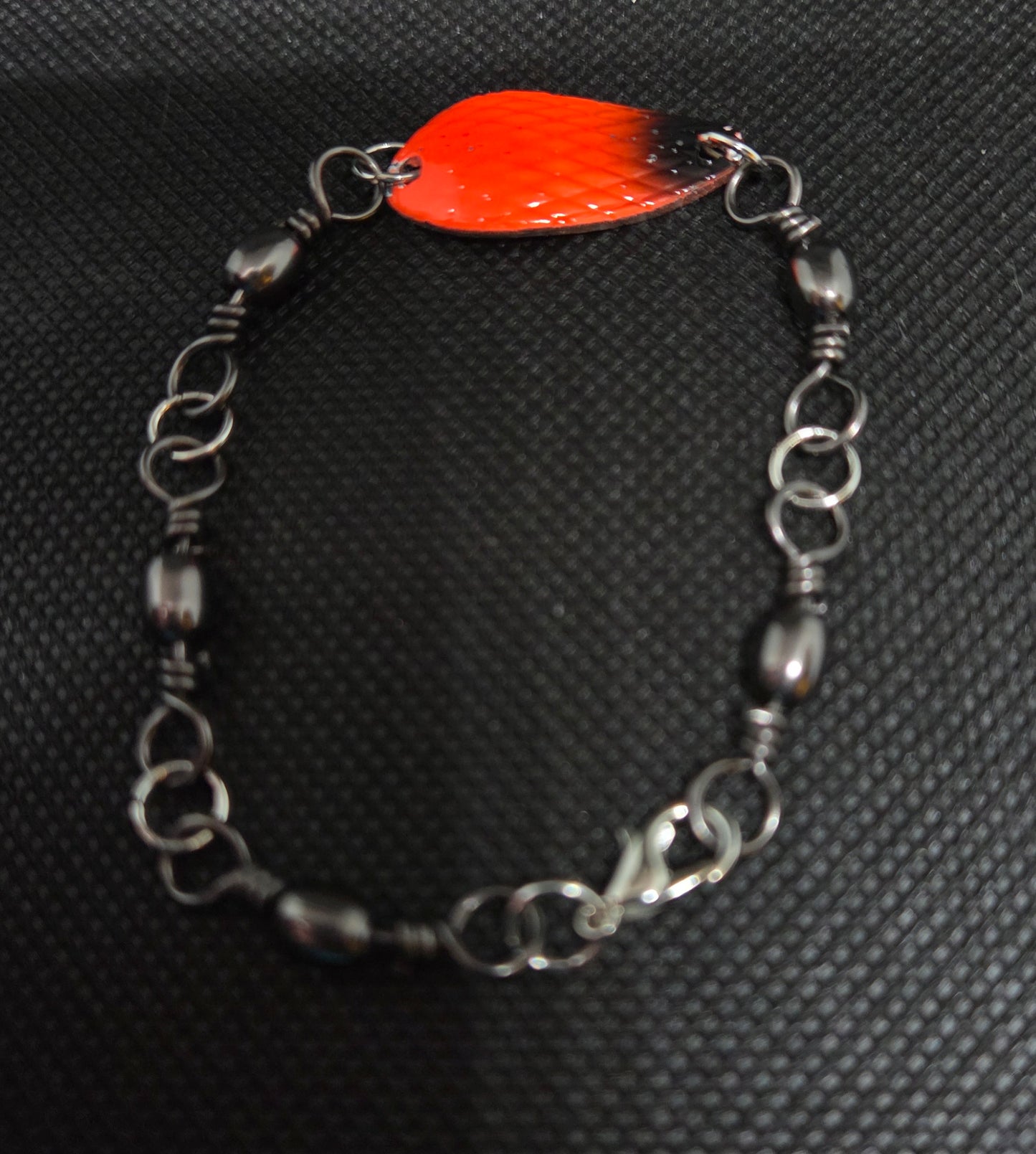 Fishing swivel bracelet with orange and black spoon lure