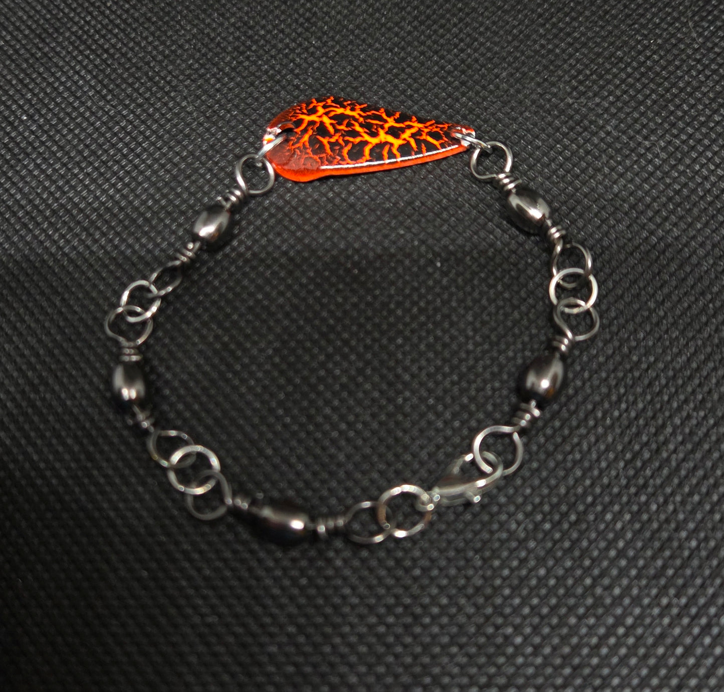 Fishing swivel bracelet with orange and black spoon lure