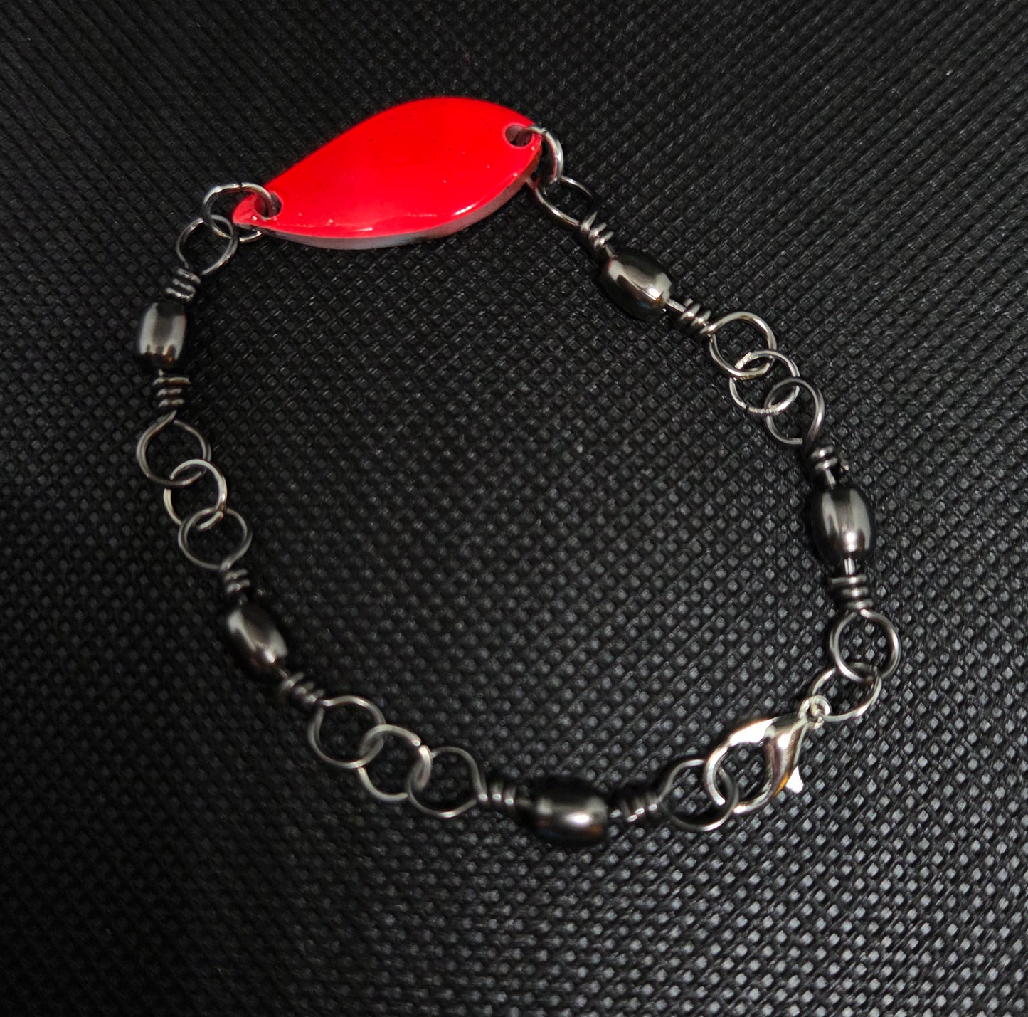 Fishing swivel bracelet with orange spoon lure