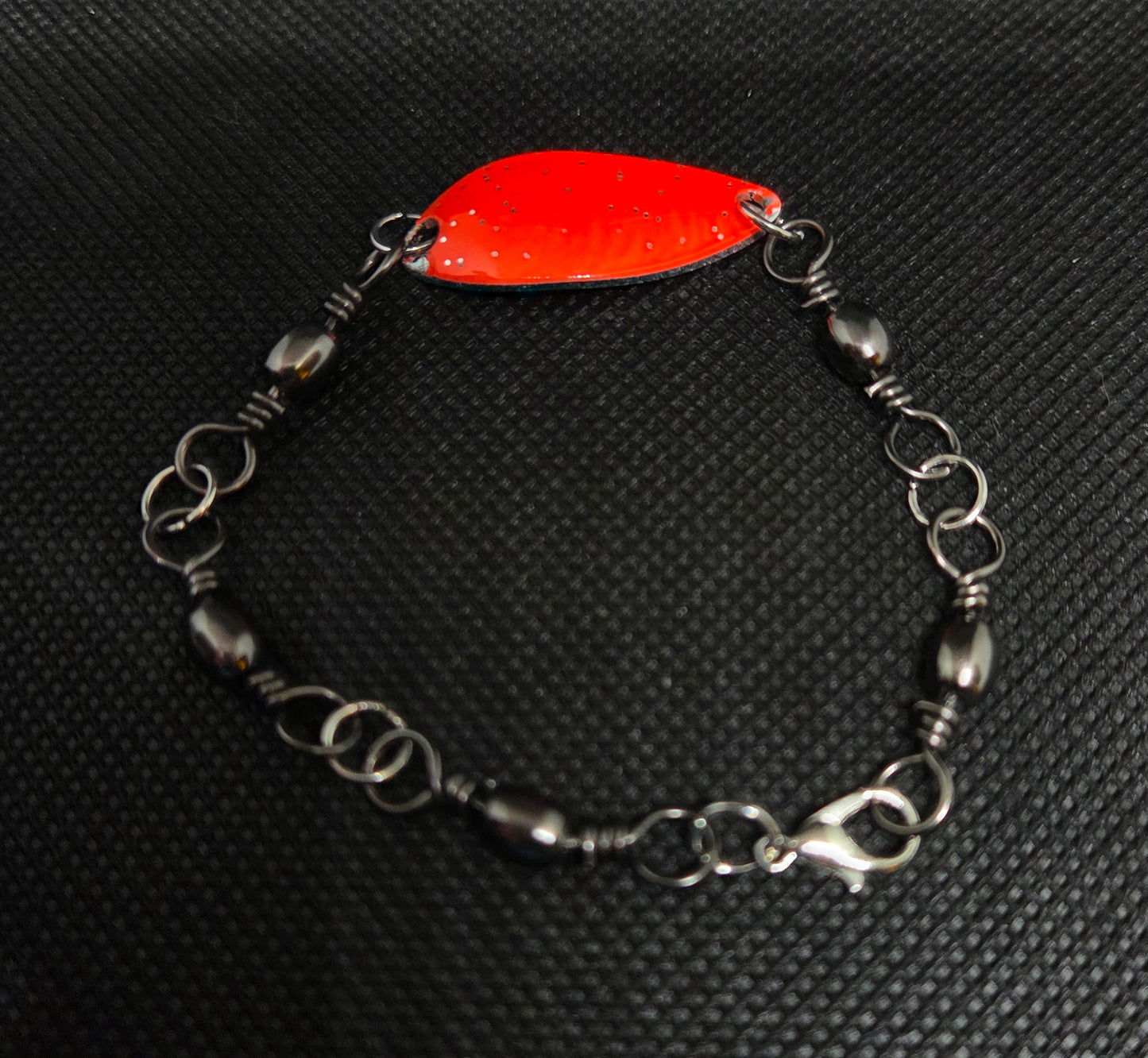 Fishing swivel bracelet with orange spoon lure